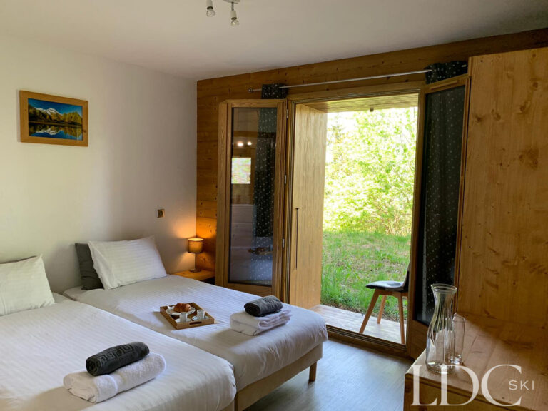 Double bedroom with doors opening onto the balcony at Chalet Edelweiss