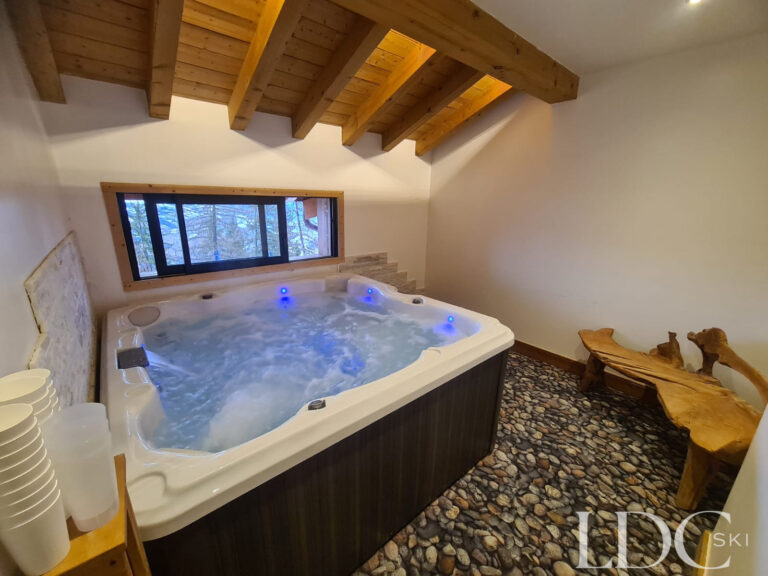 Private indoor hot tub beneath exposed timber beams at Chalet Edelweiss in Les Coches