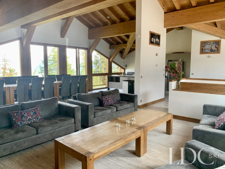 Open-plan lounge and dining area with large windows at Chalet Edelweiss