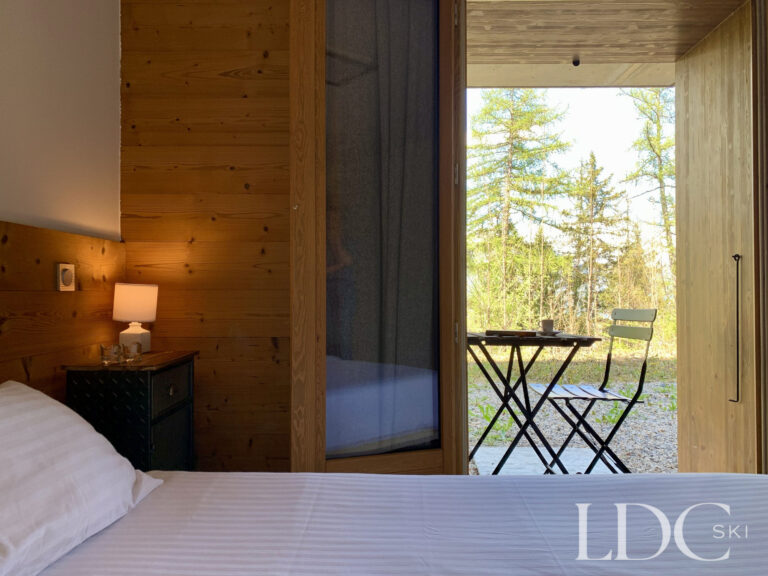 Bedroom opening onto a balcony with mountain views at Chalet Flocon