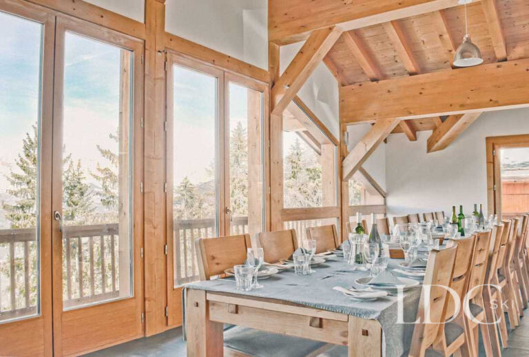 Timber-framed dining room with large windows and mountain views at Chalet Flocon in Les Coches, La Plagne