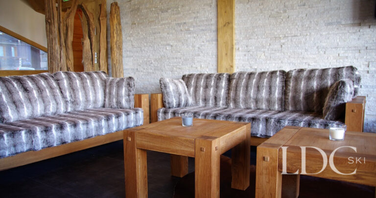 Comfortable lounge with leather sofas and timber detailing at Chalet Flocon