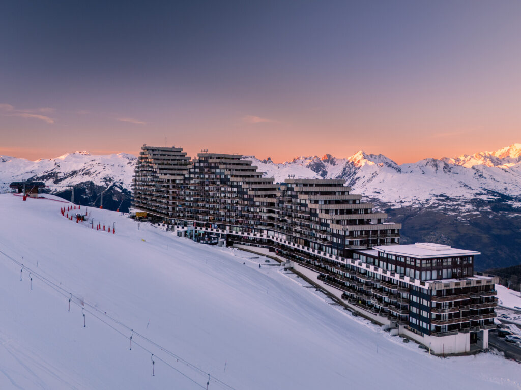 Plagne Aime 2000 at sunset surrounded by snowy mountains – © Brendan Le Peru / La Plagne