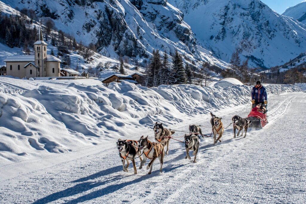 Dog sled team travelling through the snowy landscape in La Plagne – © Nomad Photographie / La Plagne