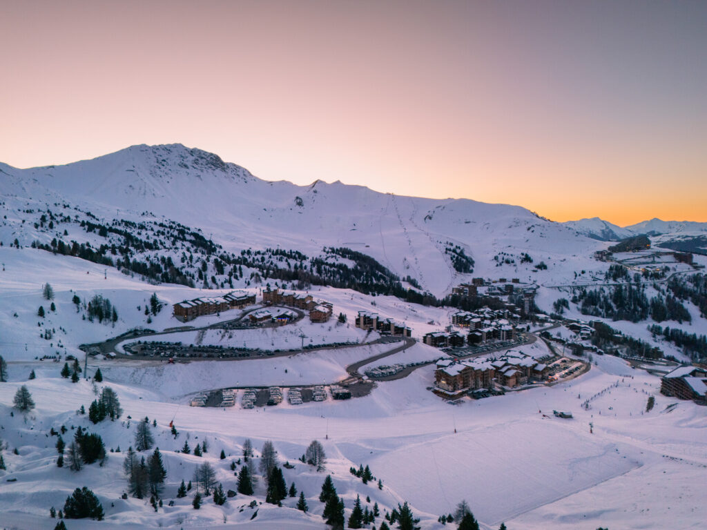 Plagne Villages at sunset surrounded by snowy ski slopes – © Brendan Le Peru / La Plagne