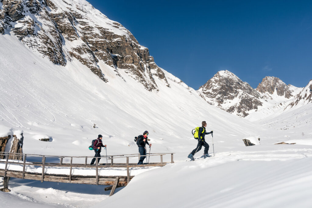 Ski tourers crossing a snowy mountain landscape in La Plagne – © Brendan Le Peru / La Plagne