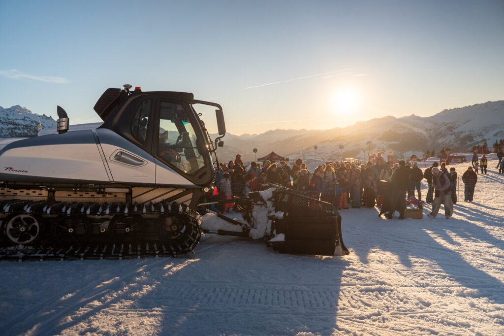 Snow groomer preparing the ski slopes at sunset in La Rosière