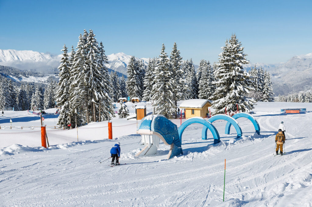Child skiing through a family area on the snowy slopes of Méribel