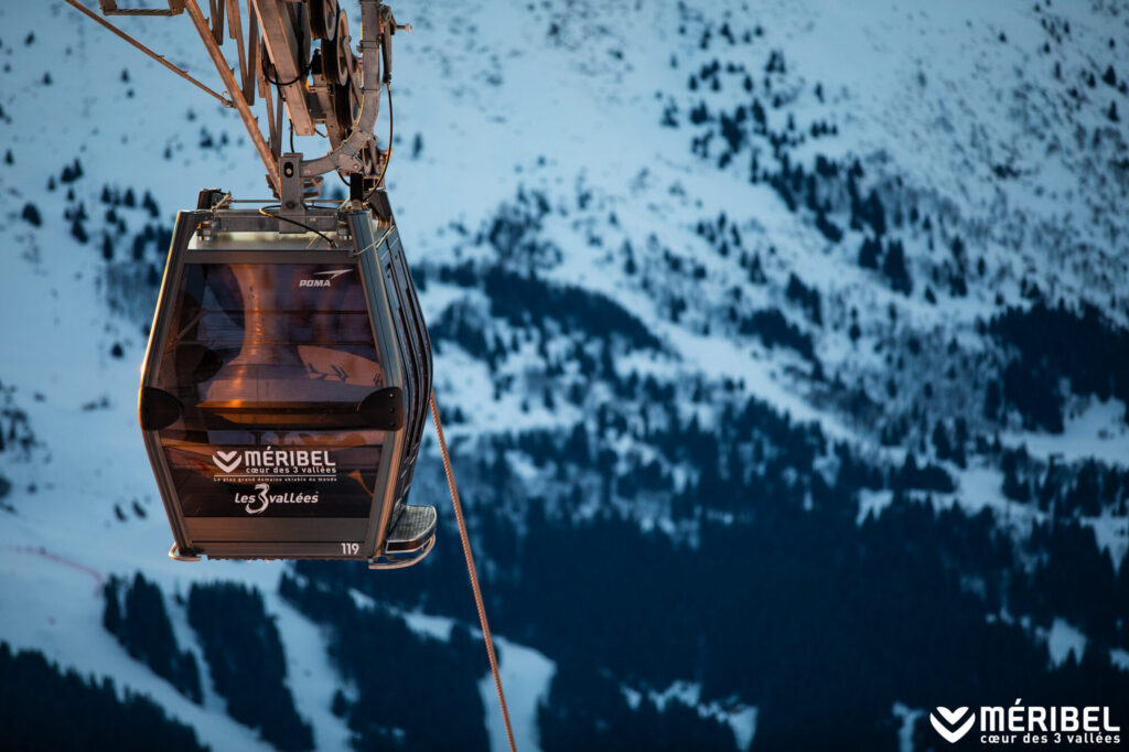 Méribel gondola travelling above the snowy mountain landscape