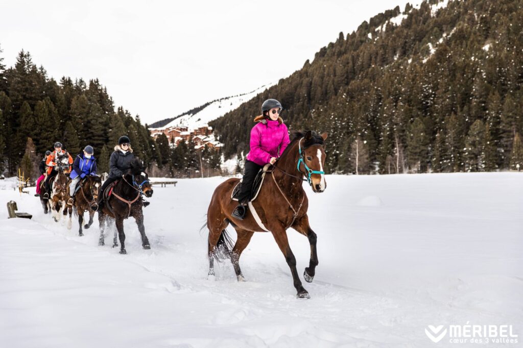 Horse riders exploring a snowy mountain trail in Méribel