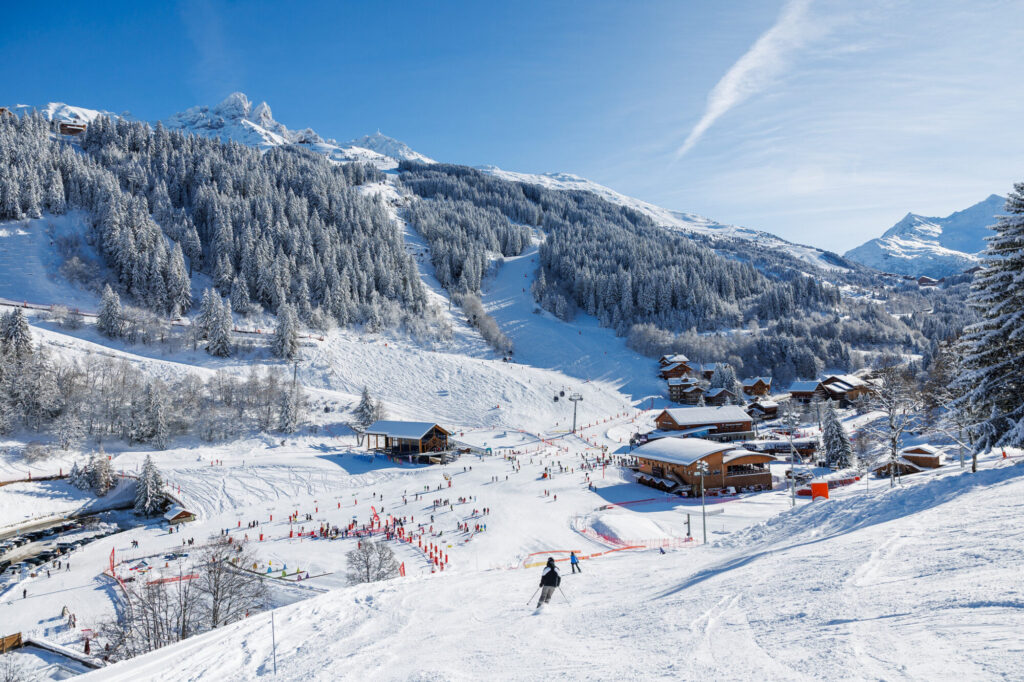 Skiers descending snowy slopes with views across the Méribel valley