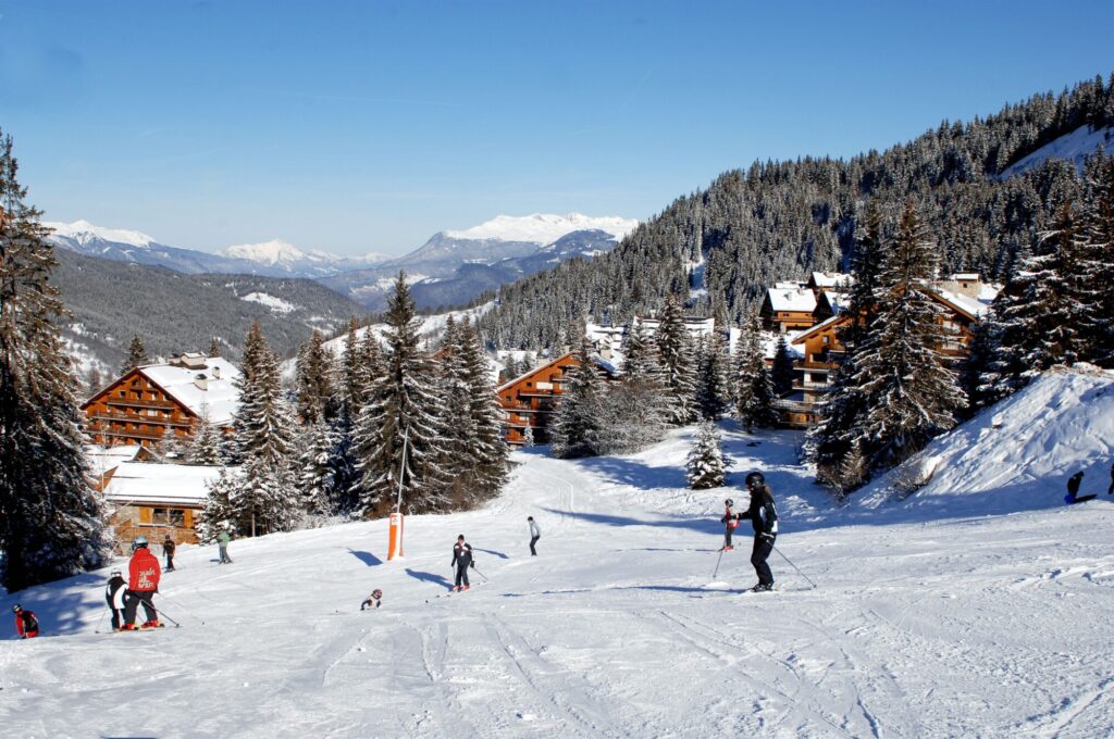 Skier on the slopes overlooking the snow-covered resort of Méribel