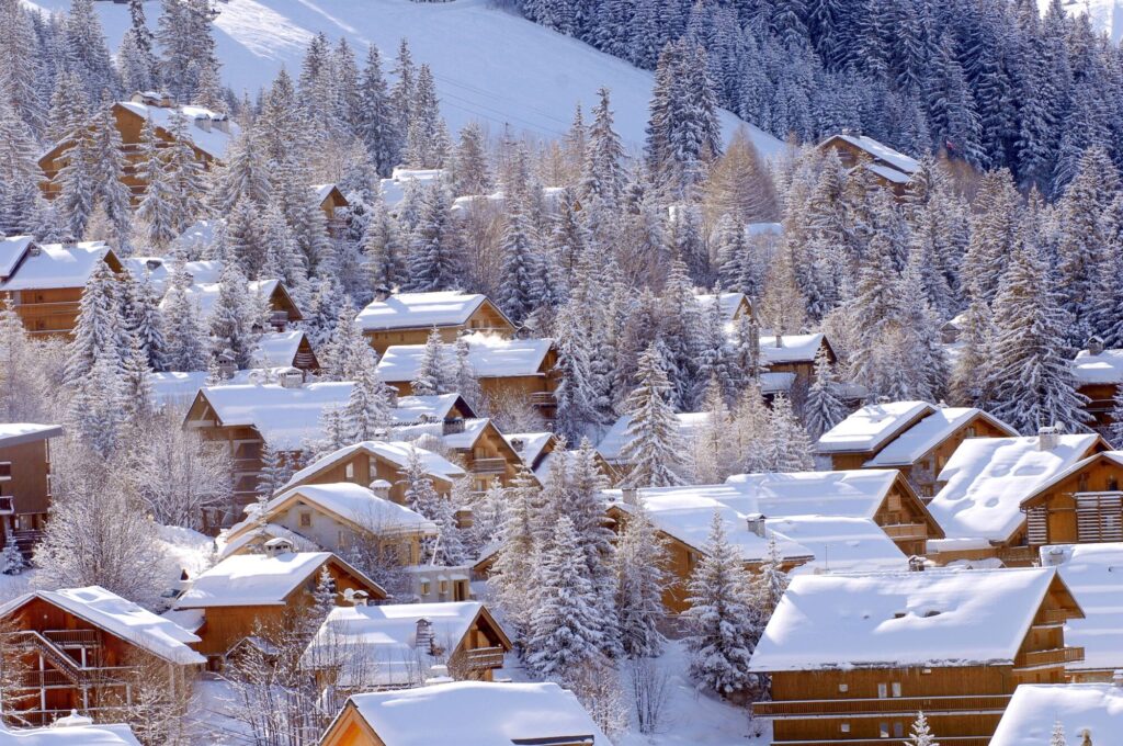 Snow-covered chalets surrounded by trees in Méribel
