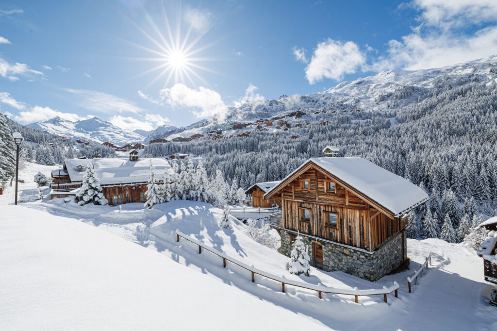 Traditional wooden chalet surrounded by deep snow and mountains in Méribel