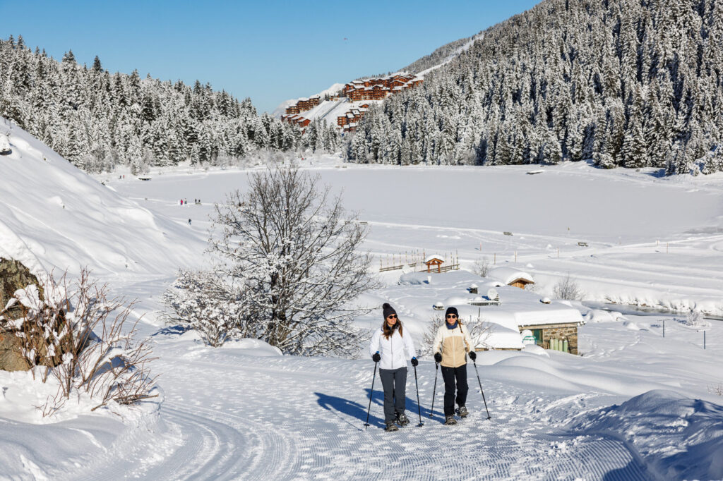 Winter walkers exploring a snowy trail in the mountains around Méribel