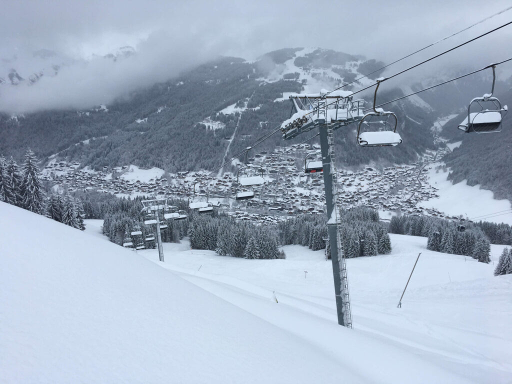 Gondola travelling above a freshly snow-covered piste near Morzine