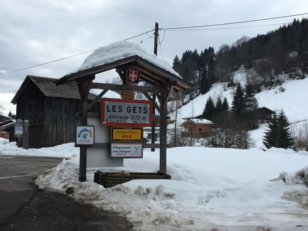 Snowy road sign marking the route towards Les Gets