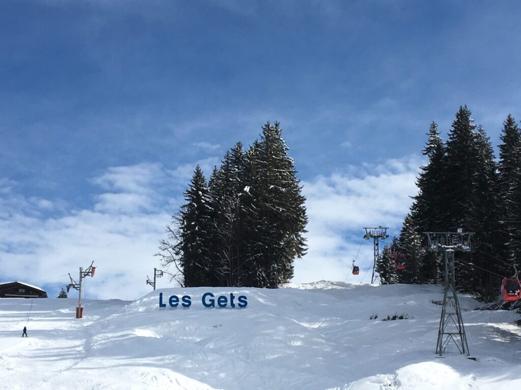 Snow-covered piste and Les Gets sign in the Portes du Soleil ski area