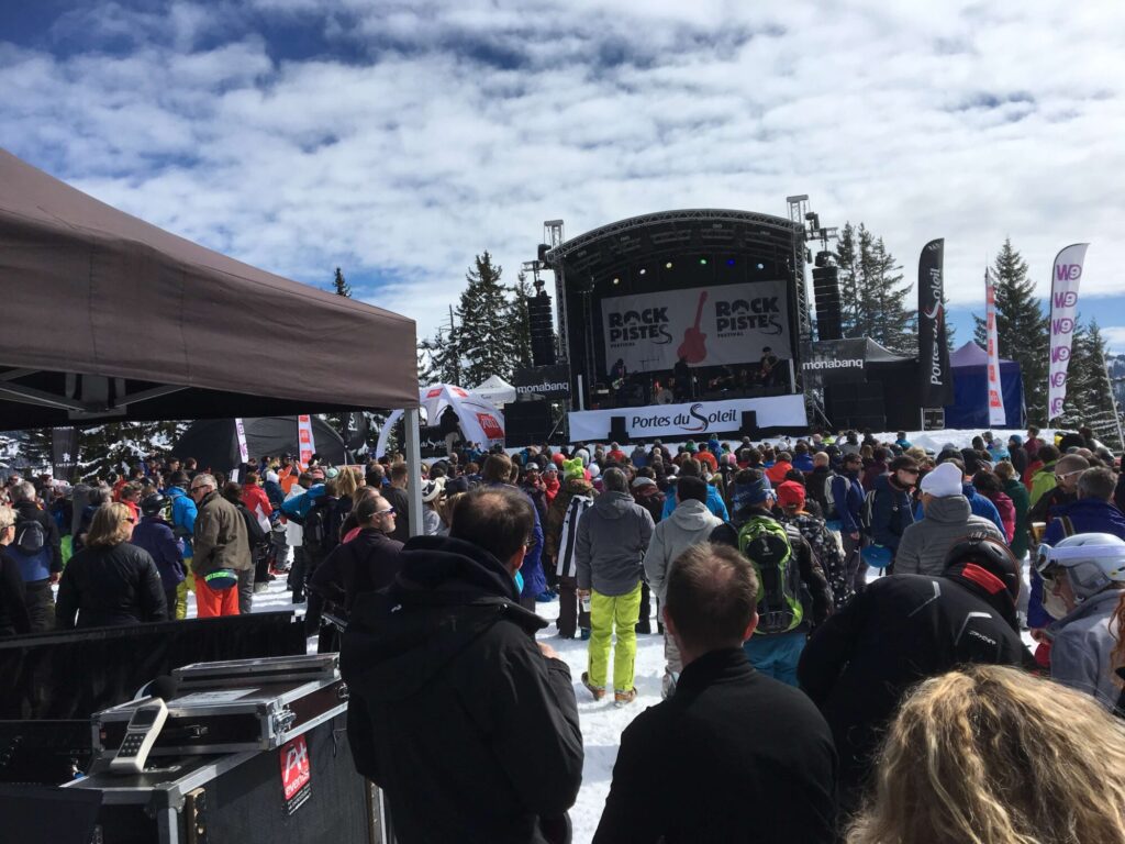 Crowd watching a live mountain concert during Rock the Pistes