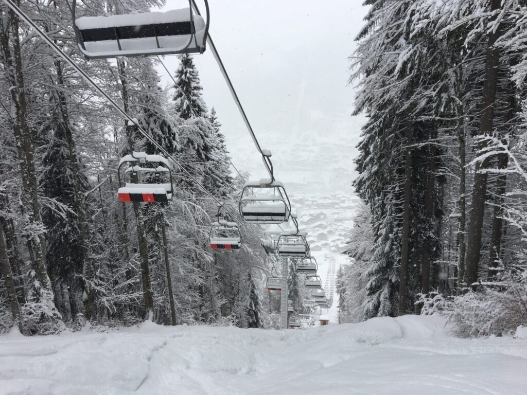 Chairlift travelling through a snow-covered forest in the Morzine ski area