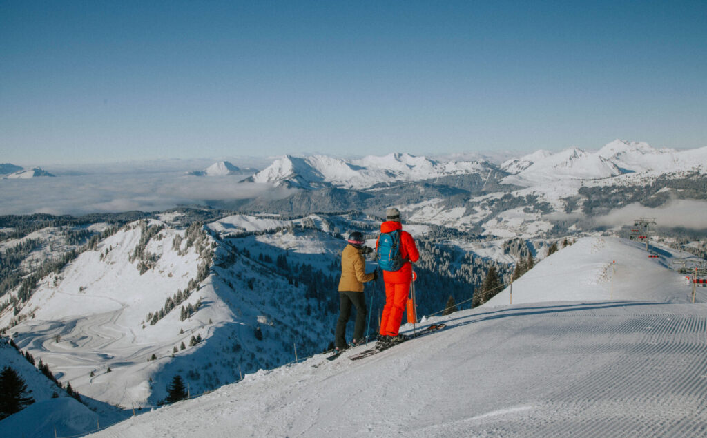 Skiers looking across the snow-covered mountains from Morzine