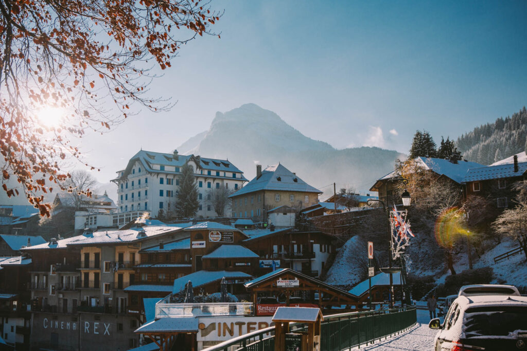 Winter street scene in Morzine with snowy mountains beyond