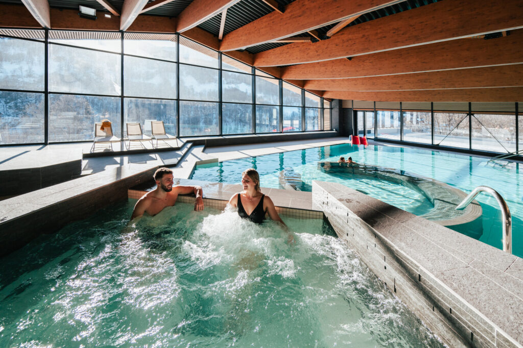 Indoor pool with floor-to-ceiling mountain views at La Belle Vie wellness centre