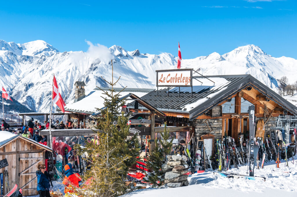 Sunny mountain restaurant terrace overlooking the peaks above St Martin de Belleville