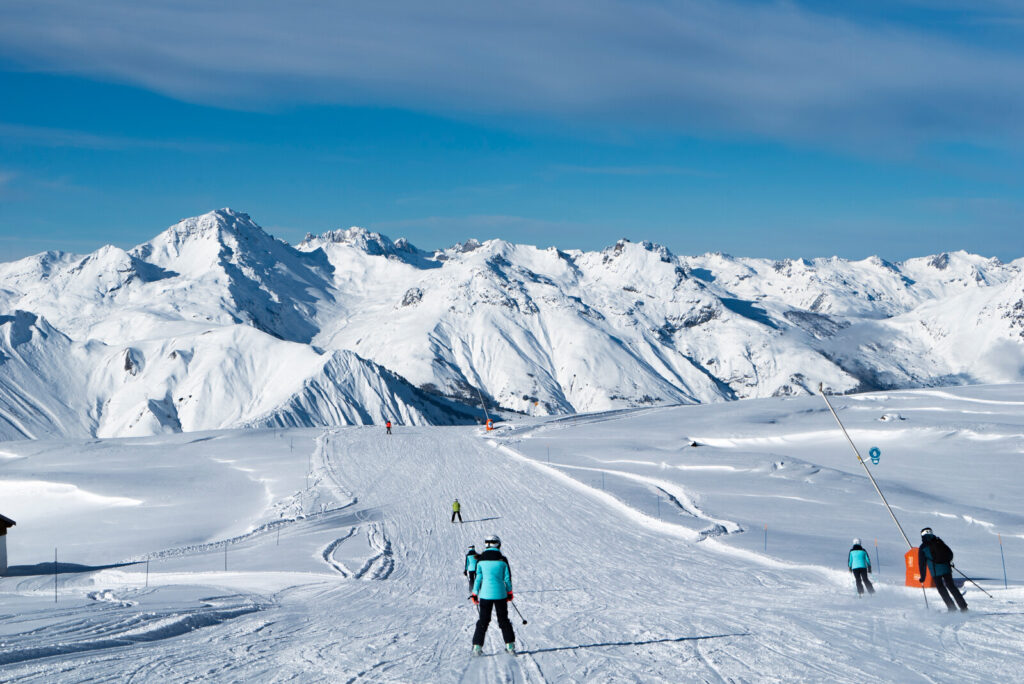 Skiers crossing the high mountain slopes above St Martin de Belleville