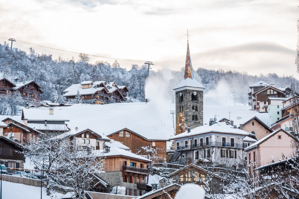 Traditional village centre and church beneath the snowy mountains of St Martin de Belleville