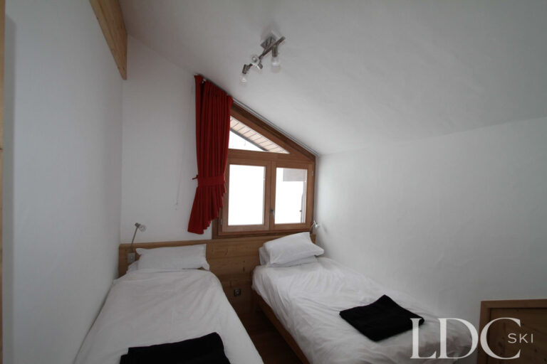 Biollay 53 twin bedroom with sloping ceiling and alpine-style timber detailing