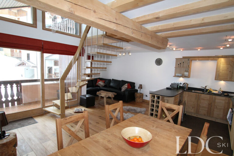 Biollay 53 open-plan lounge, dining area and kitchen with exposed timber beams