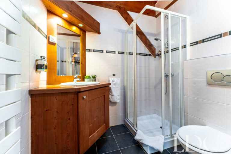 En-suite shower room with timber vanity at Cairn Lodge in Morzine