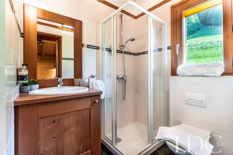 Bright shower room with window overlooking the mountains at Cairn Lodge