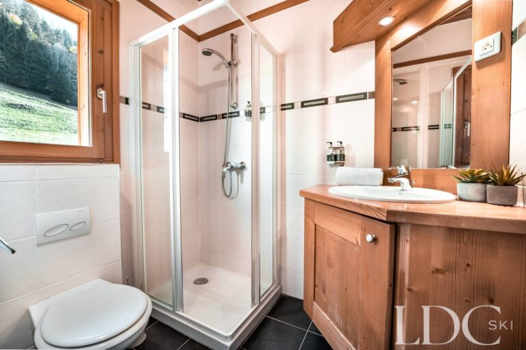 Contemporary shower room with timber vanity at Cairn Lodge in Morzine