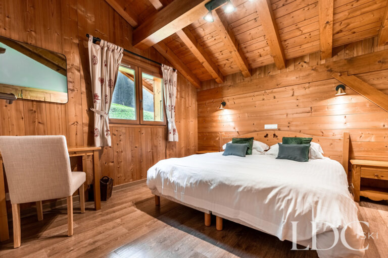 Double bedroom with traditional timber interior at Cairn Lodge