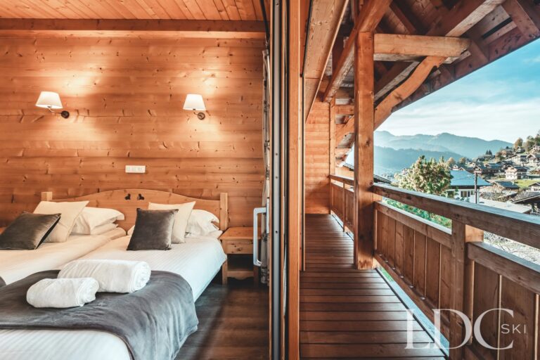 Timber-lined bedroom opening onto the balcony at Cairn Lodge