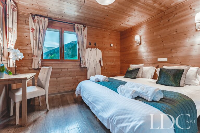 Twin bedroom with doors opening onto the balcony at Cairn Lodge