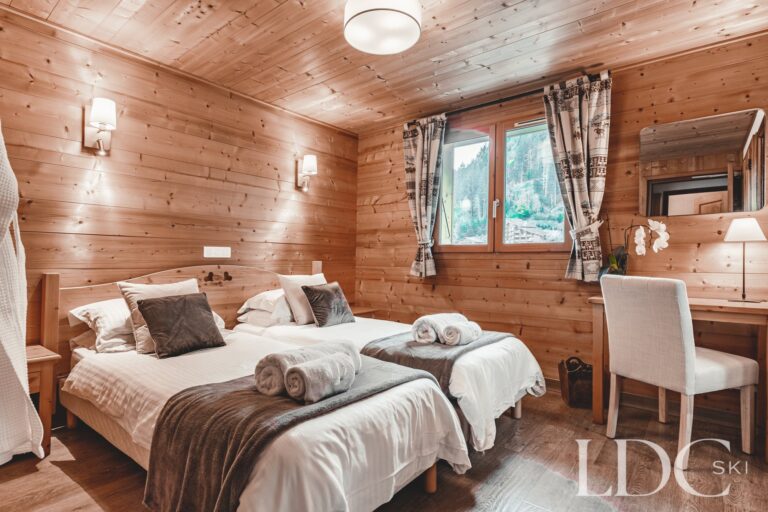 Twin bedroom with desk and timber detailing at Cairn Lodge