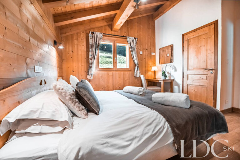 Comfortable double bedroom with timber walls at Cairn Lodge