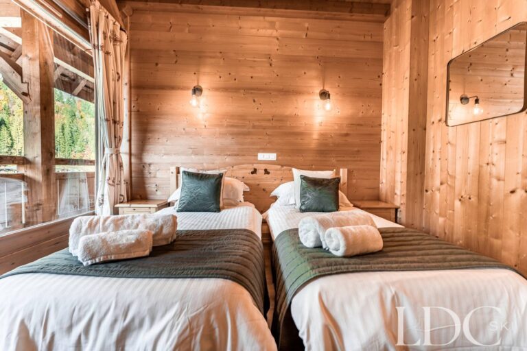 Twin bedroom with timber walls and natural light at Cairn Lodge