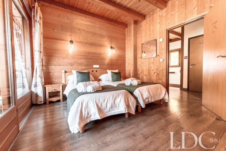 Double bedroom with doors opening onto the balcony at Cairn Lodge
