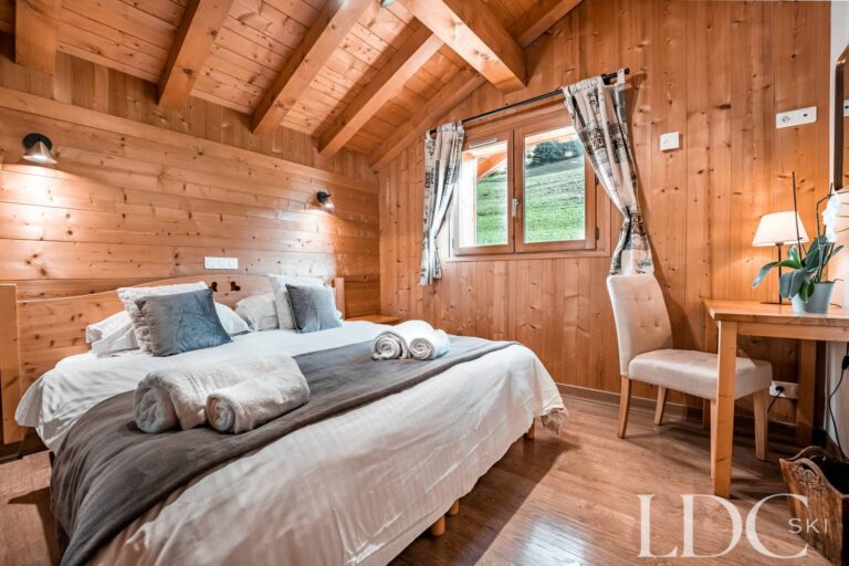 Double bedroom with desk and timber walls at Cairn Lodge