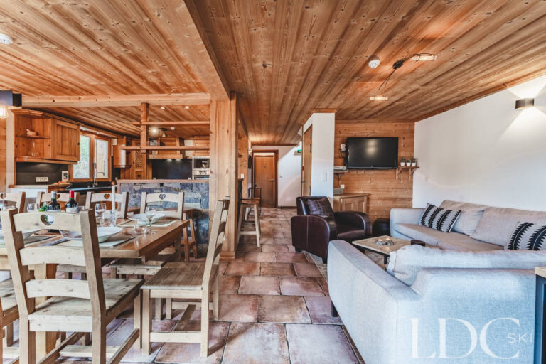Open-plan dining and lounge area with timber detailing at Cairn Lodge