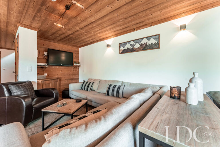 Comfortable lounge with sofas and timber fireplace at Cairn Lodge