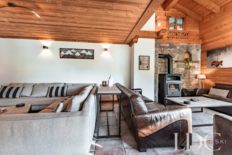 Relaxed lounge with sofas and wood-burning stove at Cairn Lodge