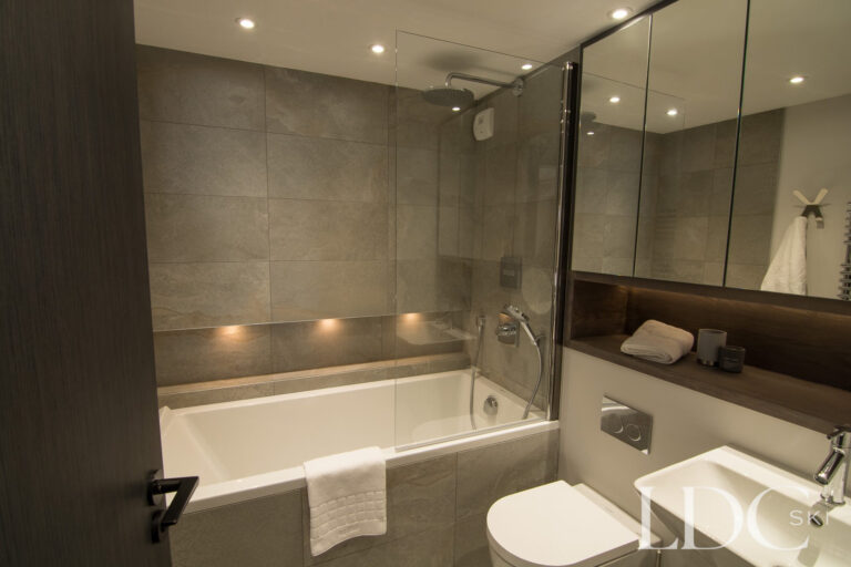 Modern bathroom with bath and overhead shower at Chalet Astilla in St Martin de Belleville