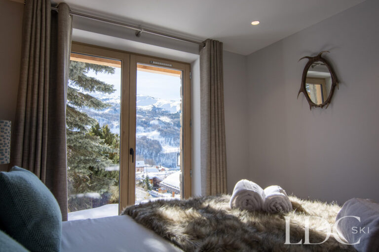 Snow-covered mountain view from a bedroom at Chalet Astilla in St Martin de Belleville