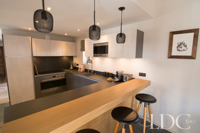 Modern open-plan kitchen with breakfast bar at Chalet Astilla in St Martin de Belleville