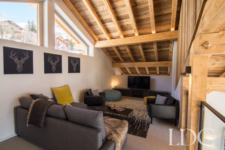 Mezzanine TV lounge at Chalet Astilla with exposed timber beams and comfortable seating